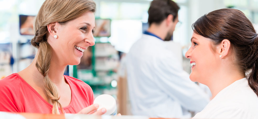 Pharmacist counsels woman in a pharmacy